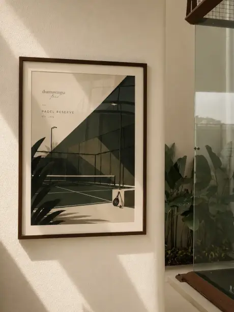 Framed print of a padel court on a cream wall
